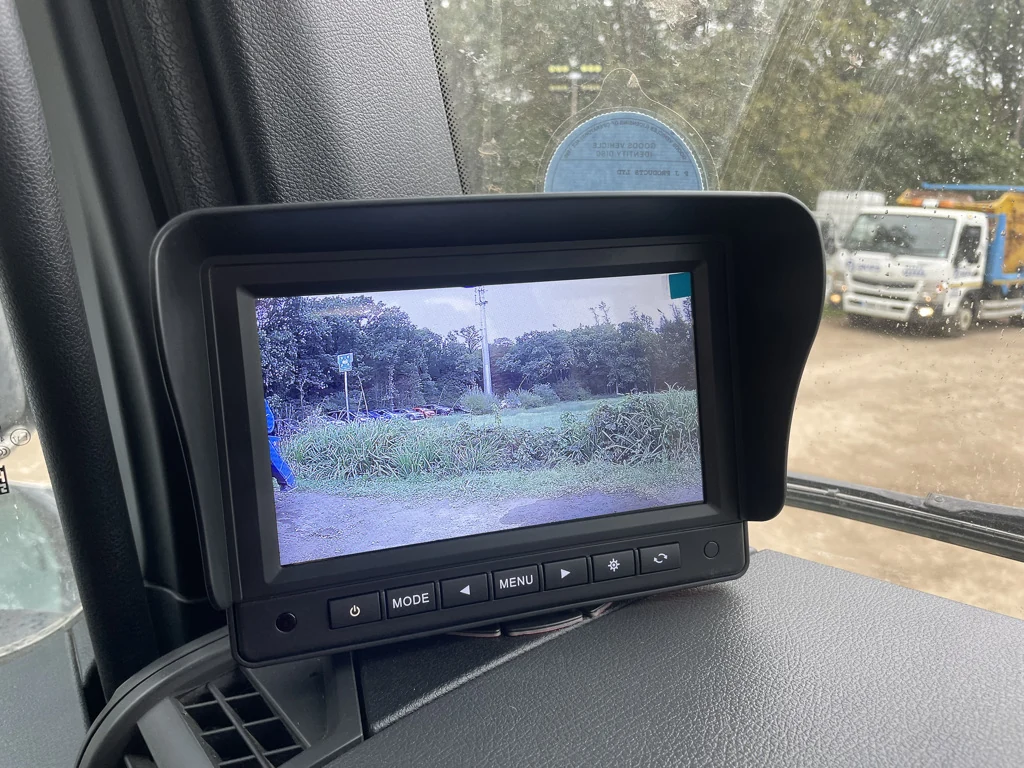 Dashboard-mounted reversing monitor in a commercial vehicle showing the rear camera view